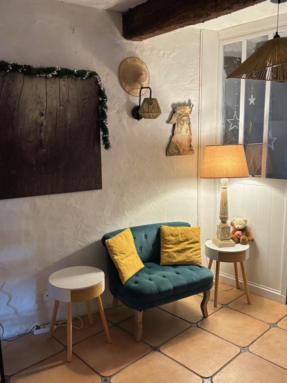 een woonkamer met een blauwe bank en een lamp bij KATELL BeachHouse in Bagnols-en-Forêt