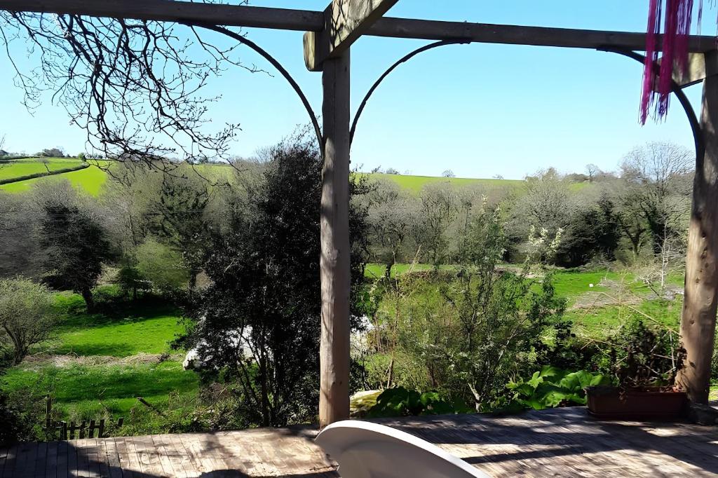 een uitzicht vanaf de veranda op de tuin bij Au restalèz in Trémargat