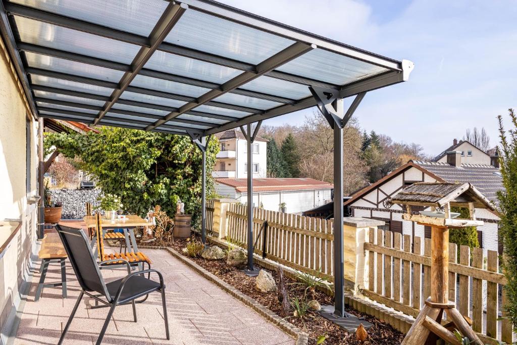 een pergola op een patio met een tafel en stoelen bij Angie's Ferienapartment in Lichtenfels