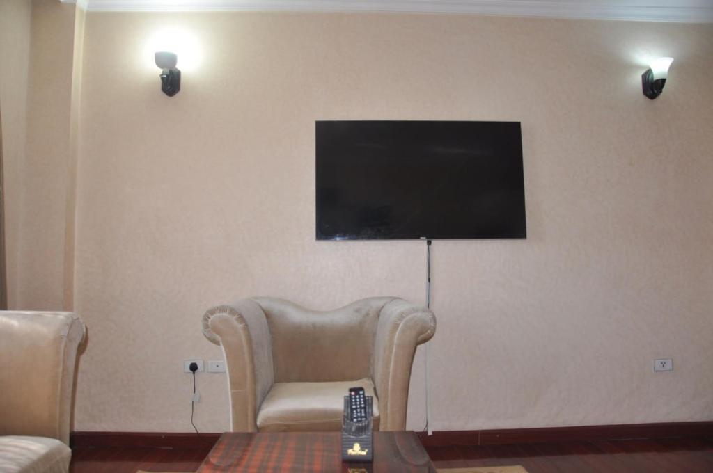 een woonkamer met een stoel en een flatscreen-tv bij Foyat Hotel in Addis Ababa