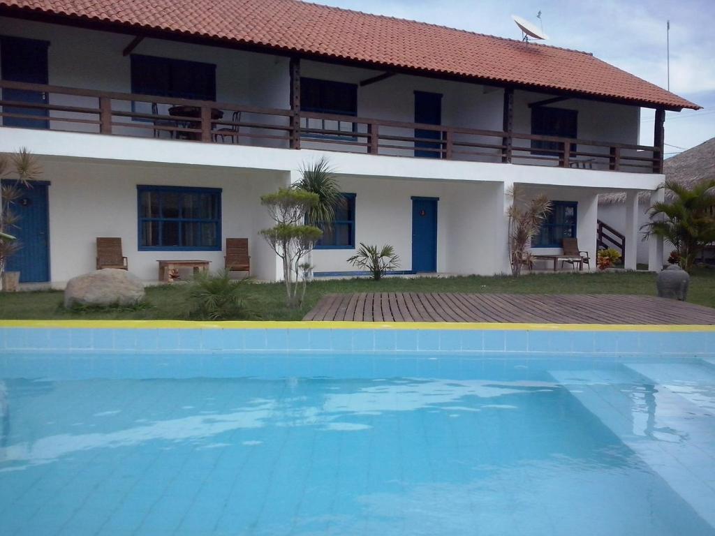 una casa y una piscina frente a una casa en Eco suites Caravelas, en Cabo Frío