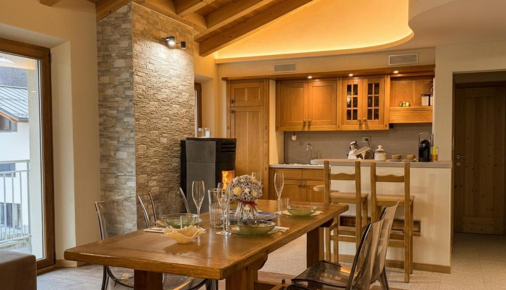 a kitchen and dining room with a wooden table and chairs at Paradiso di Grosio - mansarda con vista montagne in Grosio
