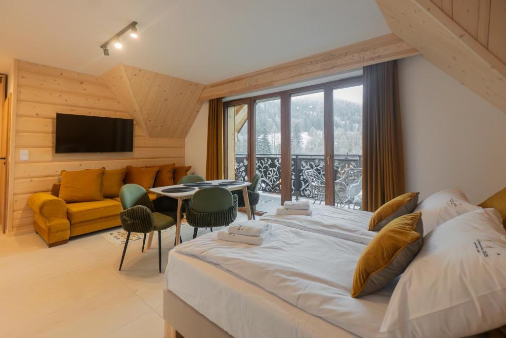 ein Schlafzimmer mit einem großen Bett und ein Wohnzimmer in der Unterkunft Jaszczurówka 33 Aparthotel & SPA in Zakopane