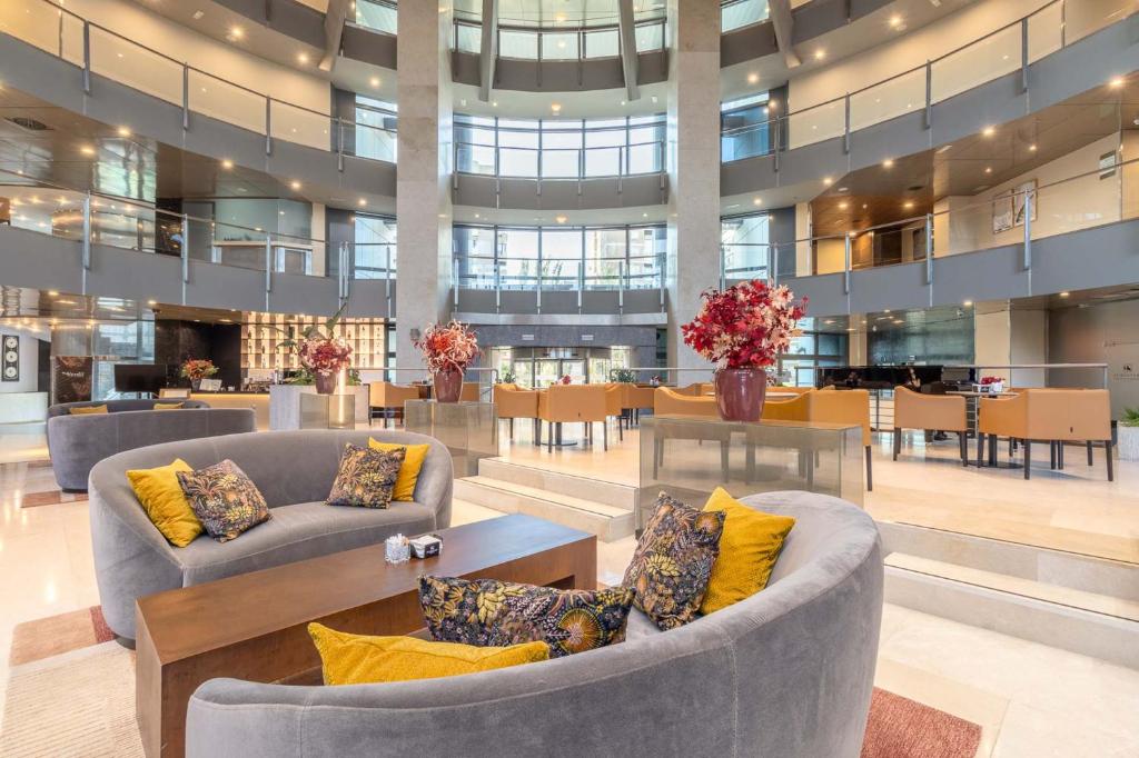 a lobby with couches and tables in a building at Eurostars Suites Mirasierra in Madrid
