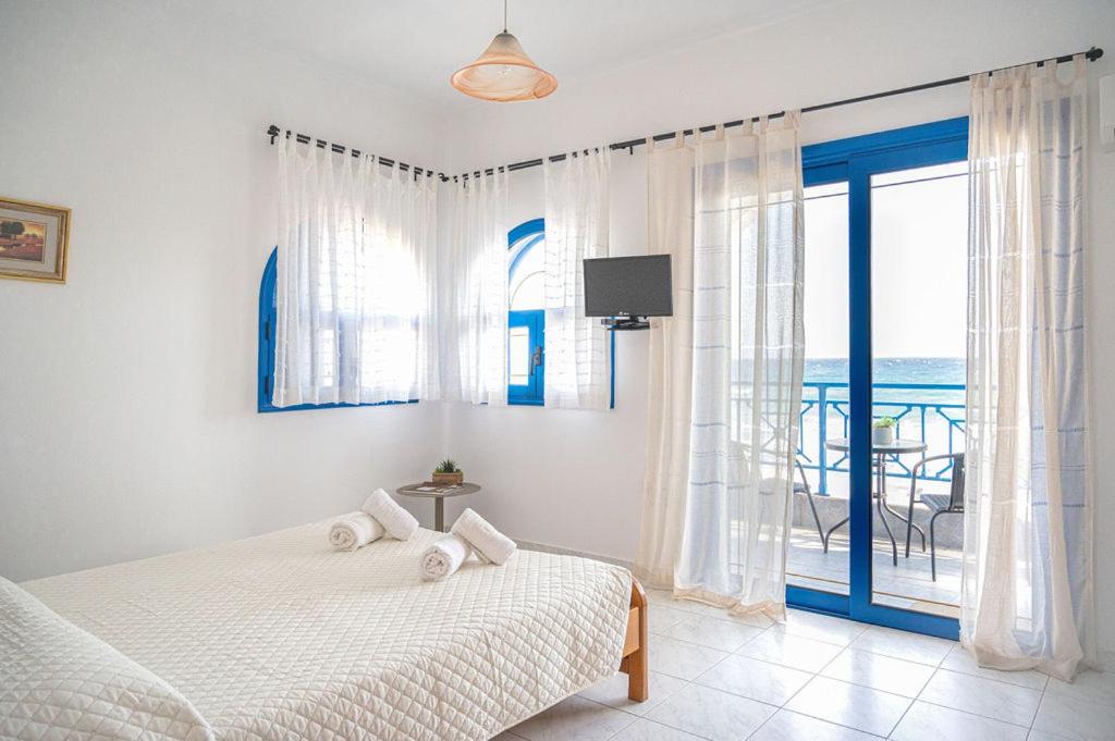 een slaapkamer met een bed en uitzicht op de oceaan bij Anna's view Stegna in Vrachonisída touArchangélou