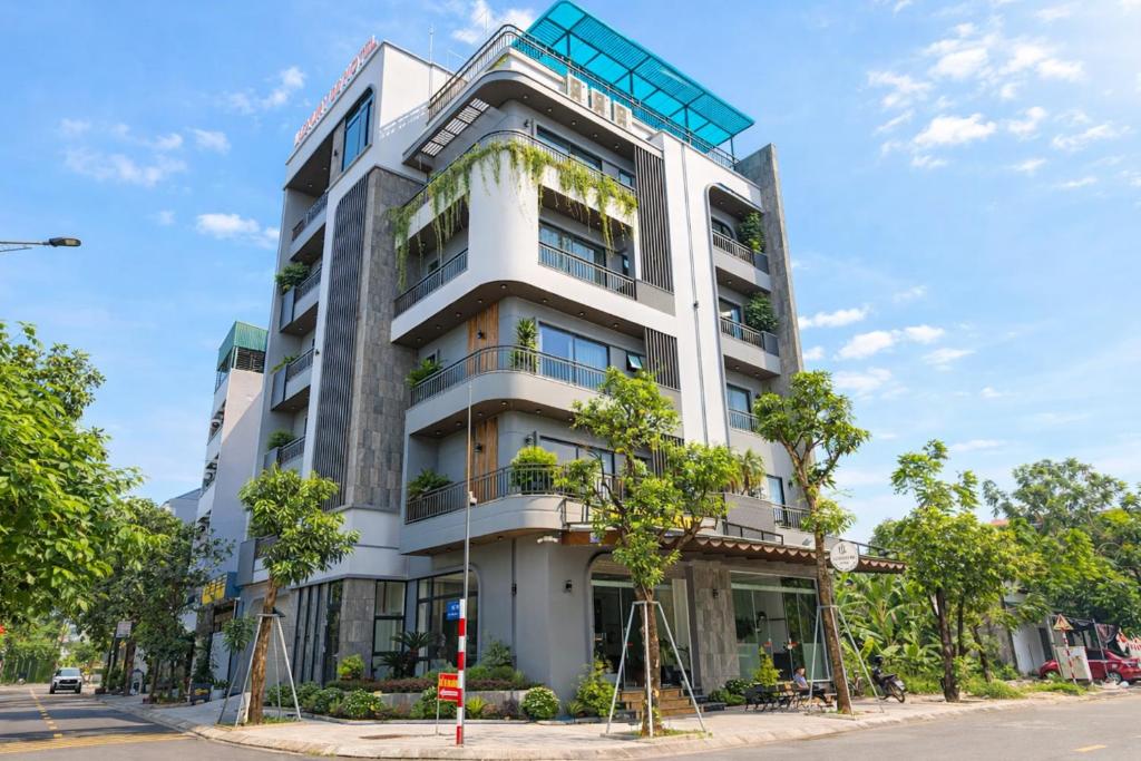 un alto edificio bianco con alberi di fronte di Luxury 88 Hotel a Phủ Lý