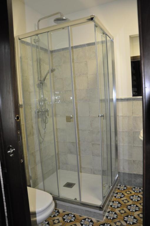 a bathroom with a glass shower with a toilet at Casa de las Remigias in Estepona