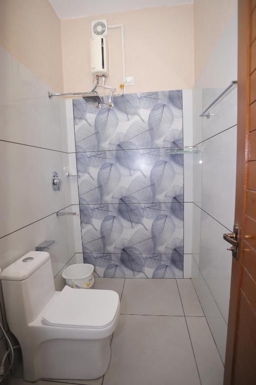 ein weißes Badezimmer mit Toilette und Dusche in der Unterkunft NALINAM HOMESTAY in Thiruvananthapuram