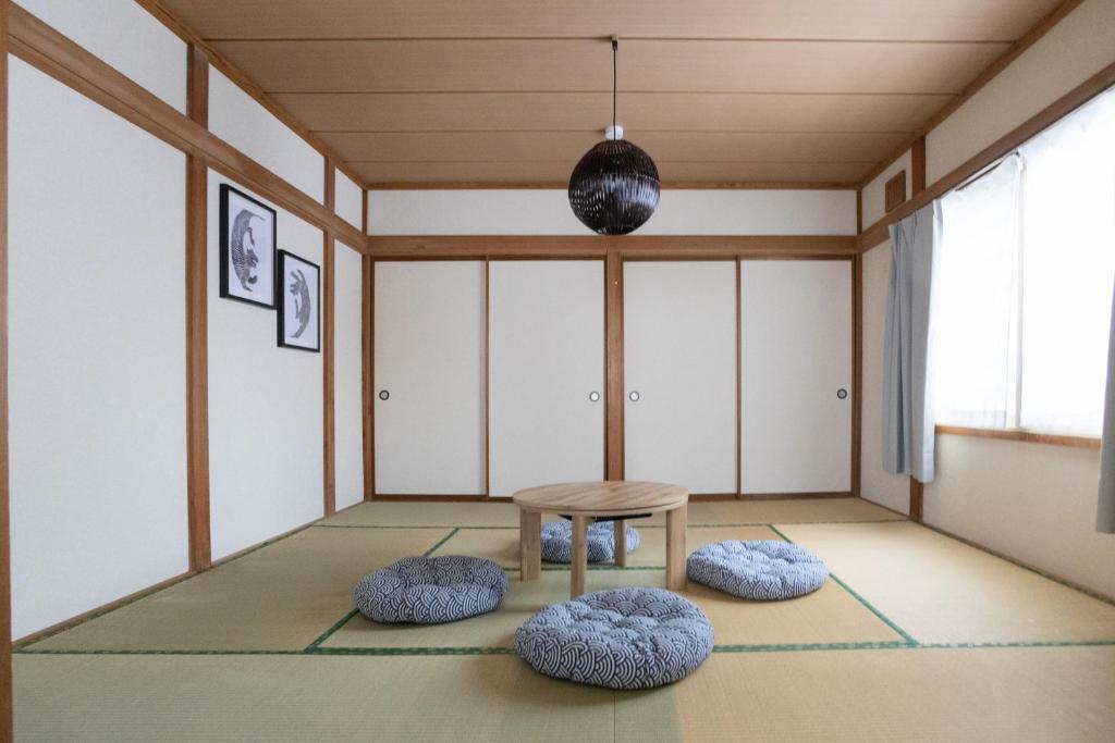 een kamer met een tafel en twee poeven bij Niseko Homey Home in Kutchan