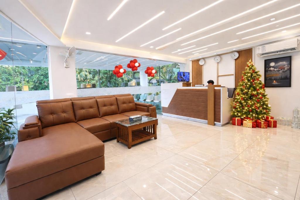 ein Wohnzimmer mit einem Weihnachtsbaum und einer Couch in der Unterkunft Stay Bridge Residency in Kozhikode