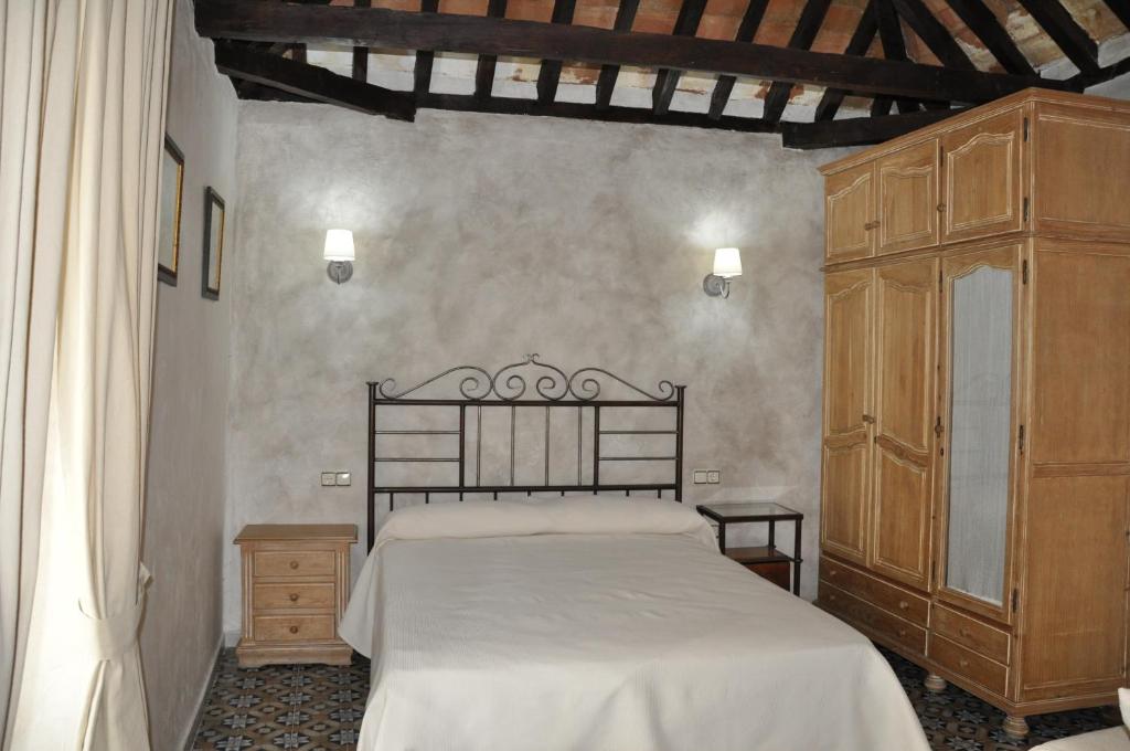 a bedroom with a large bed and a wooden cabinet at Casa de las Remigias in Estepona