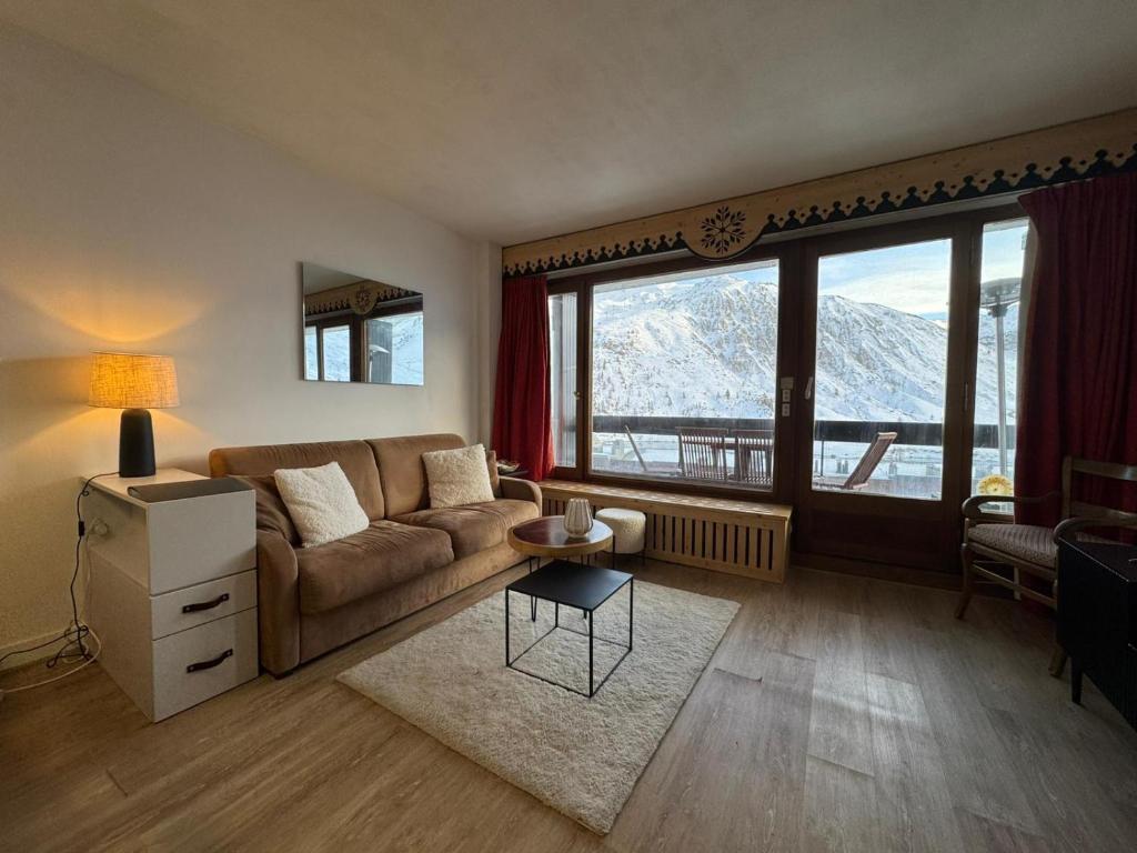 ein Wohnzimmer mit Couch und großem Fenster in der Unterkunft BEC452- Superbe 2 pièces, vue Lac - Tignes in Tignes