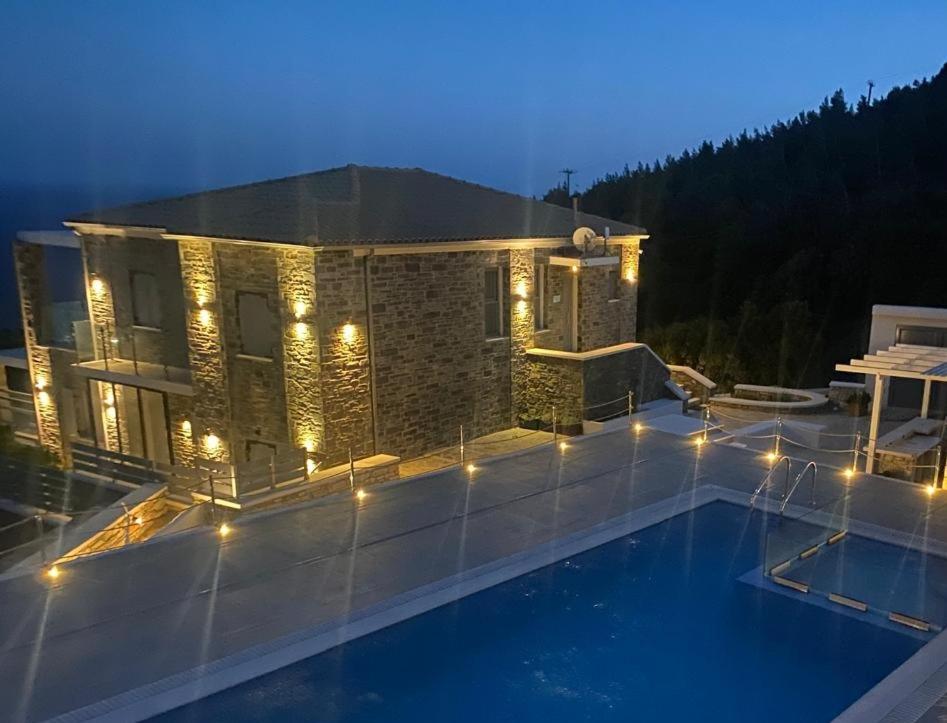 een huis met een zwembad 's nachts met verlichting bij Villa Dolihi in Agios Kirykos
