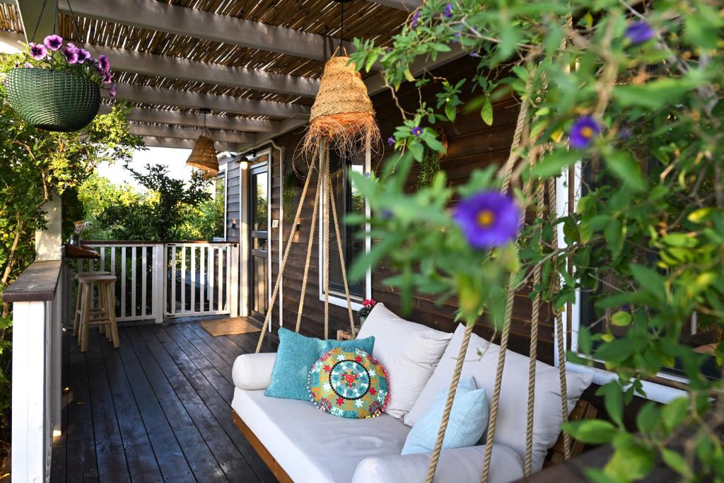 a porch with a swinging couch on a patio at בקתת שקד Shaked Cabin in Natur