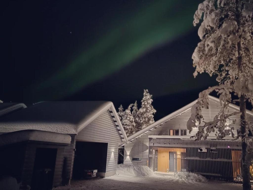 un'immagine di una casa con l'aurora nel cielo di Rusty Reindeer Levi a Levi