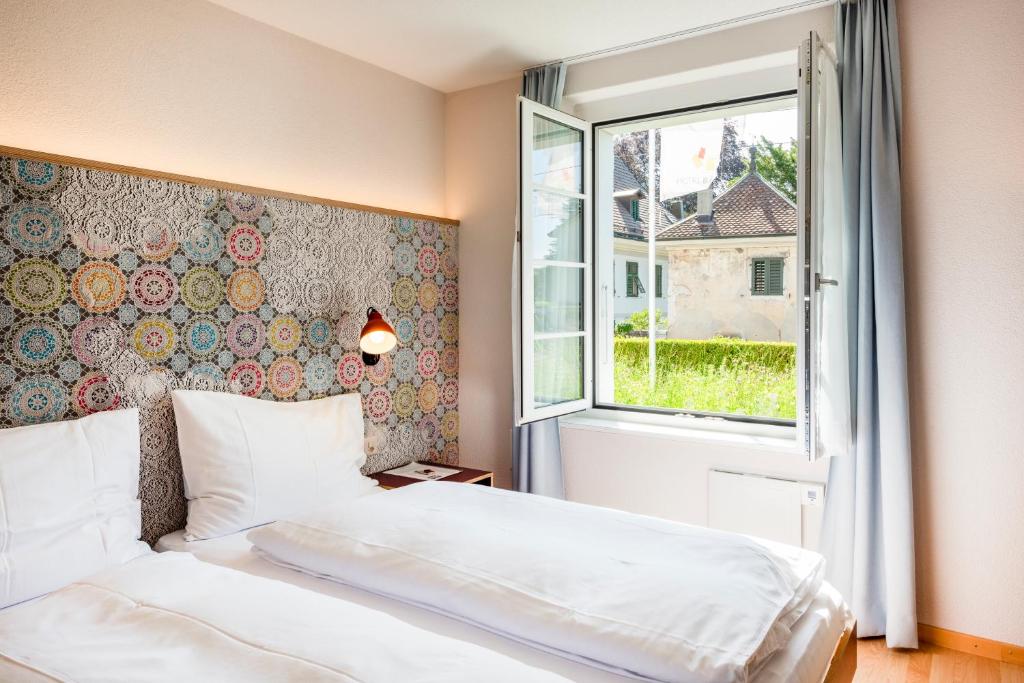 een slaapkamer met een bed en een raam bij Bären Self Check-in Hotel in Solothurn