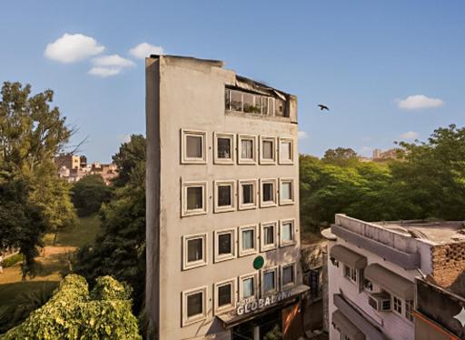 ein hohes weißes Gebäude mit Seitenfenstern in der Unterkunft Hotel Global Inn in Amritsar
