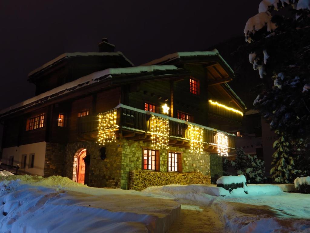 ツェルマットにあるChalet Huwi Zermattの雪面のクリスマスライトで覆われた建物