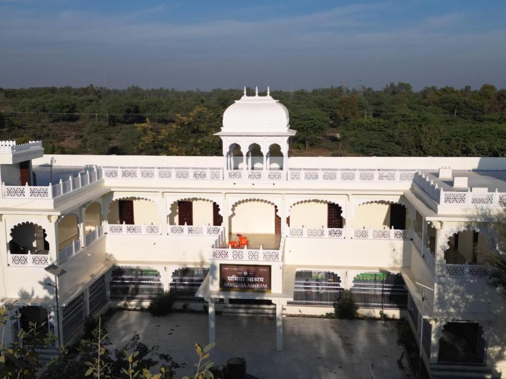 ein weißes Gebäude mit einem Turm darauf in der Unterkunft Chandra Bagh in Māvli