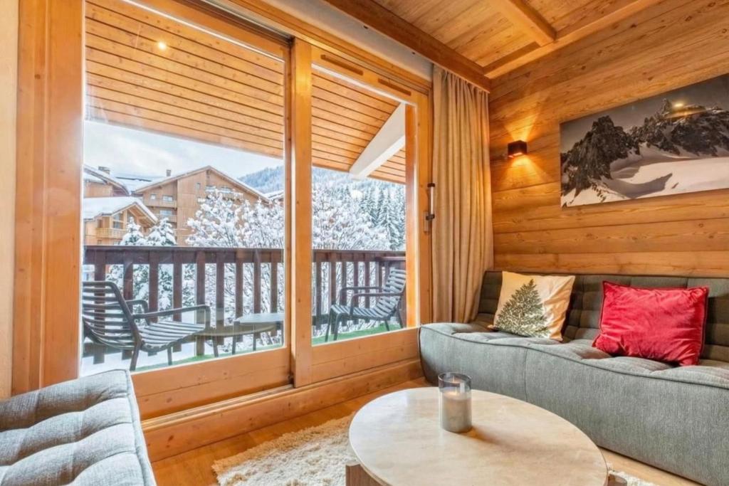 ein Wohnzimmer mit einem großen Fenster in einer Hütte in der Unterkunft Troillet 11 in Méribel