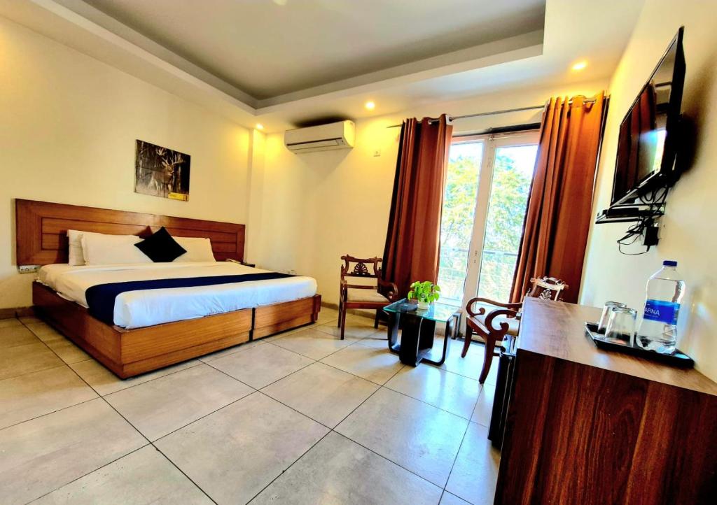 a bedroom with a bed and a television in it at Stays - NH 8 in Gurgaon