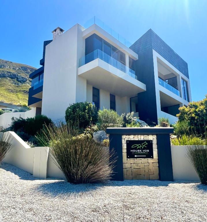 a white house with a sign in front of it at House Vos in Hermanus