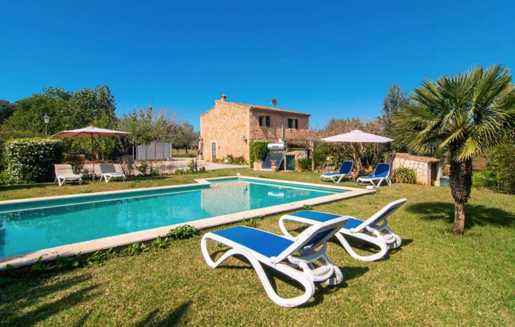 een zwembad met 2 ligstoelen en een huis bij Villa Sa Mata in Campanet