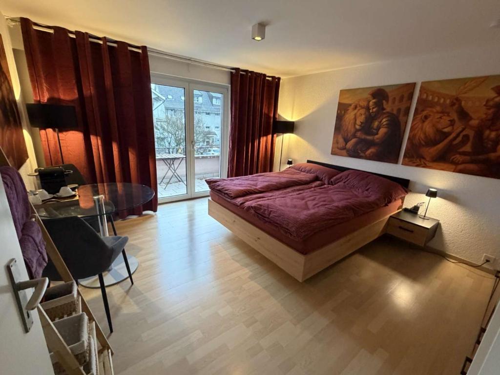 een slaapkamer met een bed, een tafel en een raam bij Centurio 5 in Baselaugst