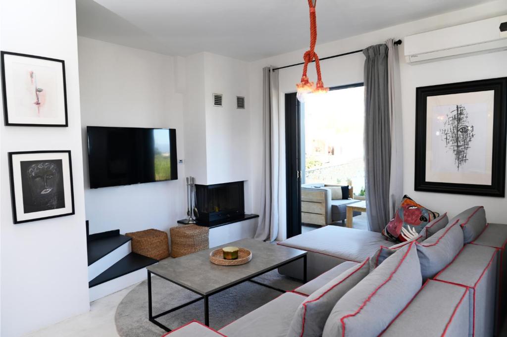 a living room with a couch and a tv at Hydra House Nafplio in Myloi
