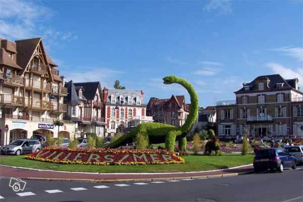 a large green snake sculpture in the middle of a street at Le Cottage in Villers-sur-Mer
