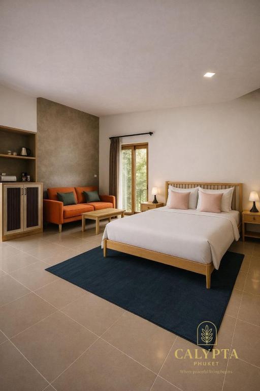 een slaapkamer met een groot bed en een bank bij Calypta Resort Phuket in Phuket