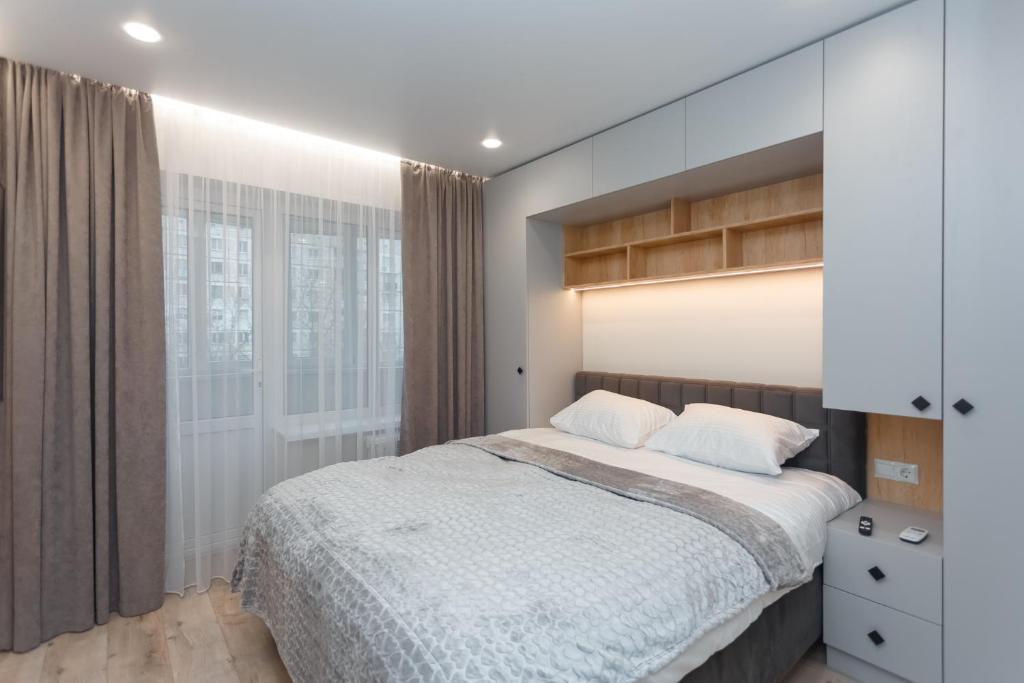 a bedroom with a large bed and a window at HomeRent Petru Zadnipru in Chişinău