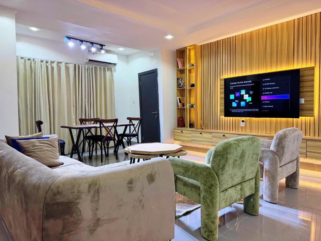 a living room with a couch and a flat screen tv at The Colony in Mama