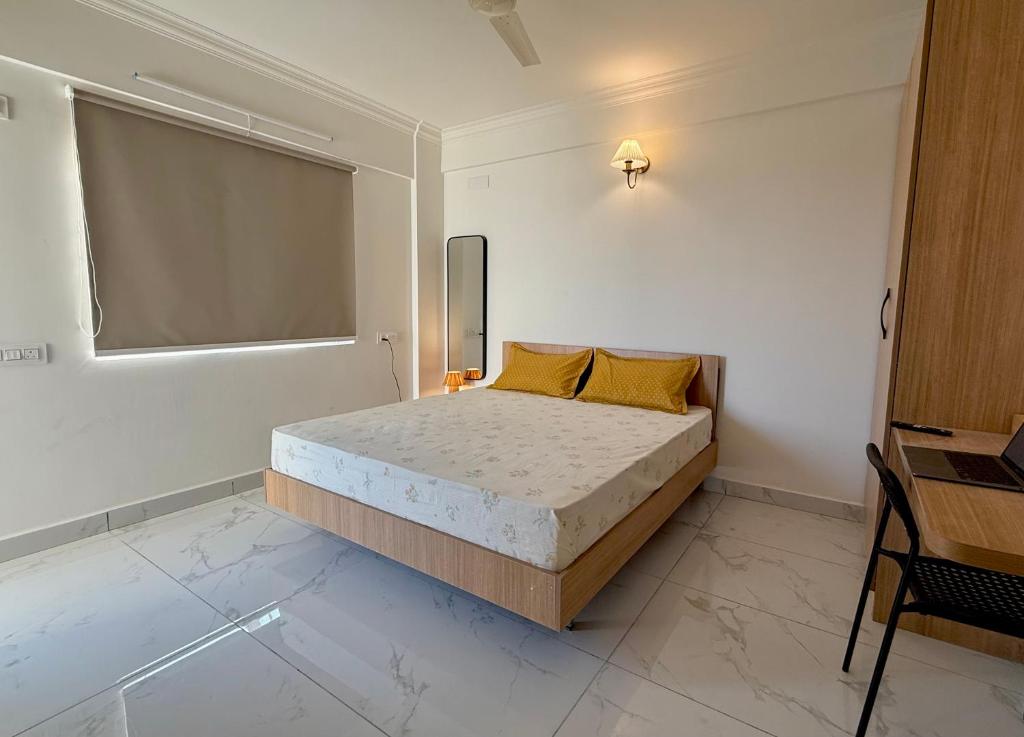 une chambre avec un lit dans une pièce blanche dans l'établissement HomeSlice Sarjapur - Balcony Rooms, à Bangalore