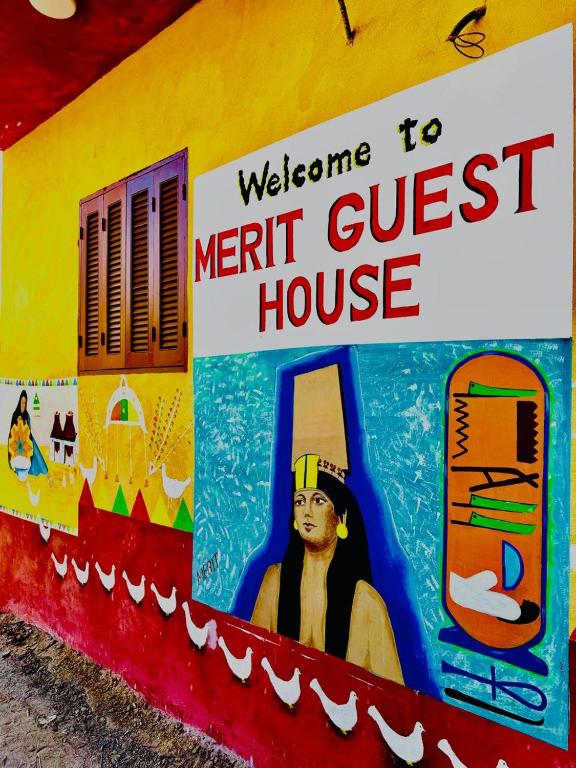 a sign for a merit guest house on a wall at MERIT Guest House in Aswan