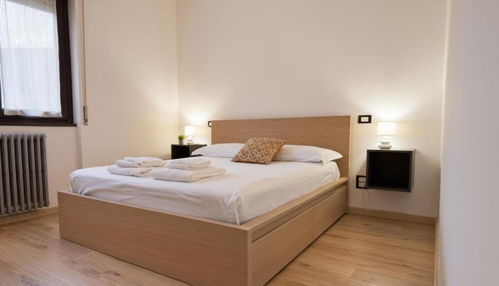 a bedroom with a large bed with towels on it at Carbonera 4 - casetta vicina alla Stazione in Tirano