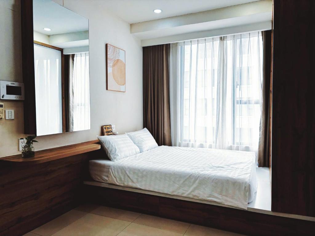 a bedroom with a bed and a large window at The Lume Studio - Tresor D4 in Ho Chi Minh City