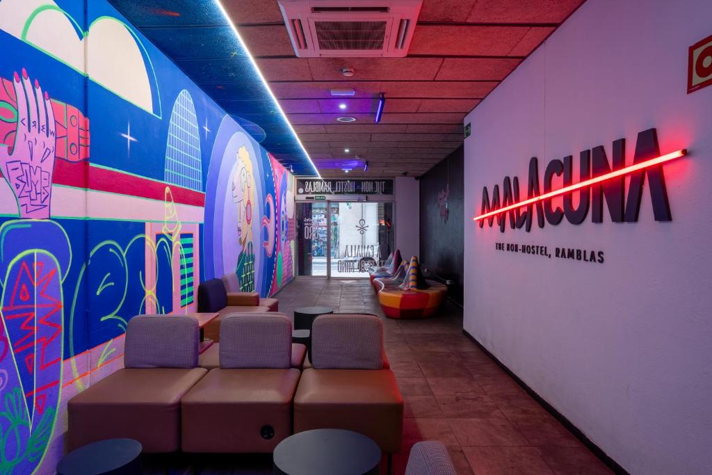 una sala d'attesa con sedie e una parete con tavole da surf di Ideal Youth Hostel a Barcellona