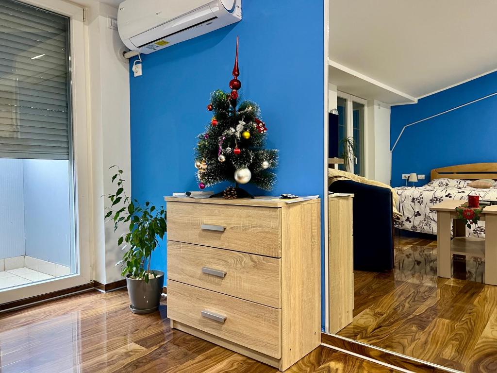 un albero di Natale sopra un comò in una stanza di Stan na dan Flower a Šabac