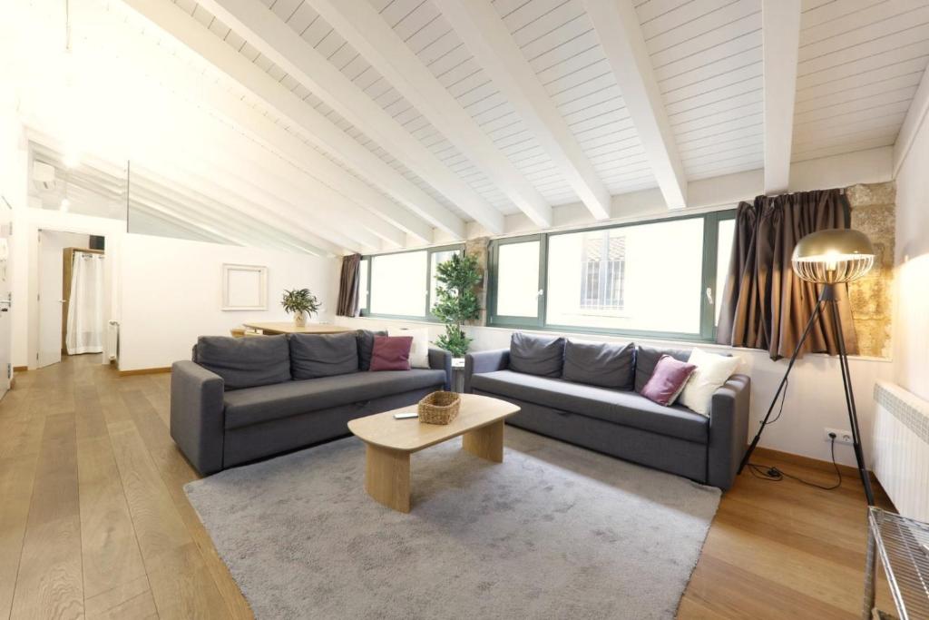 un salon avec un canapé et une table dans l'établissement Bravissimo Força 17, Barri Vell apartments, à Gérone