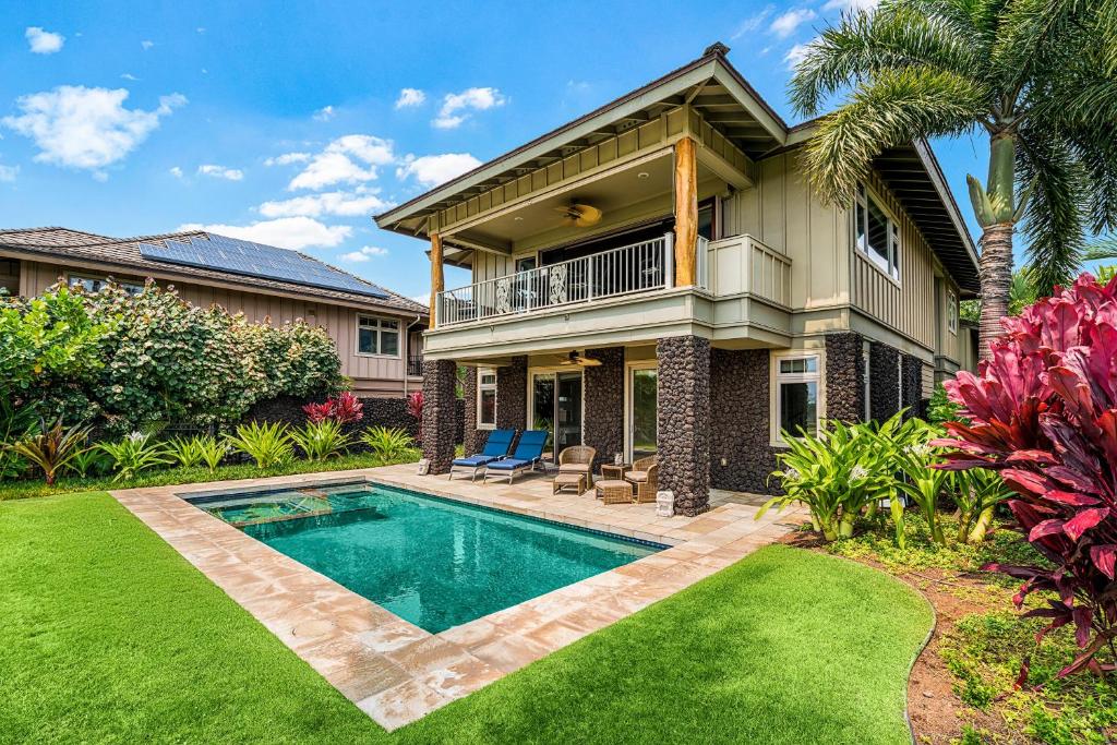 een huis met een zwembad in een tuin bij KaMilo Villa Heated Pool Golf Course Views Beach Club Access in Waikoloa