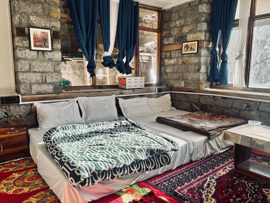 een bed in een kamer met blauwe gordijnen bij High on hills in Kalgha