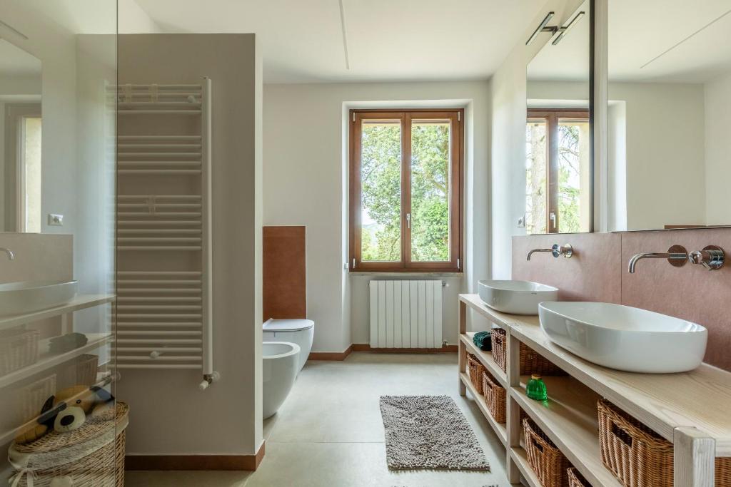 een badkamer met 2 wastafels en een toilet bij "Villa Bizzi" in Monte Castelli