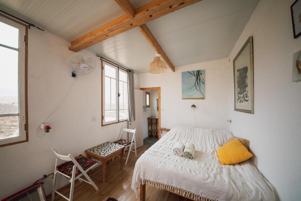una camera da letto con un letto, un tavolo e una finestra di כרם שיזף a Mitzpe Ramon