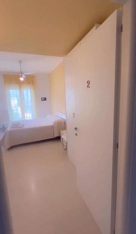 a white room with a bed and a door at Aurea Suites in Palermo