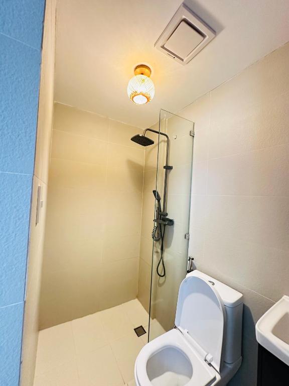 a bathroom with a toilet and a glass shower at Saffron Villa in Pampang