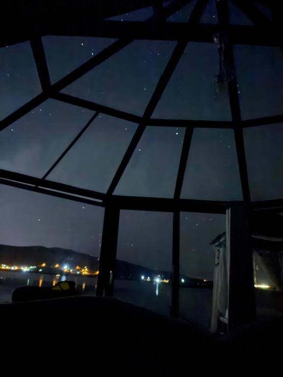Blick auf den Nachthimmel durch ein Fenster in der Unterkunft Uros bungalows TITICACA in Puno