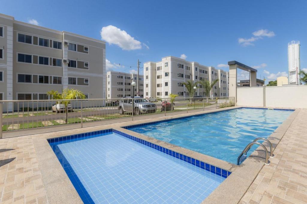 a large swimming pool in front of a building at Apartamento próximo Aeroporto Cuiabá in Várzea Grande