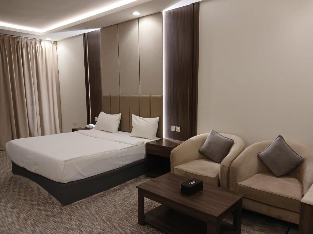 a hotel room with a bed and a couch at سفن روز للشقق المخدومة in Rabba