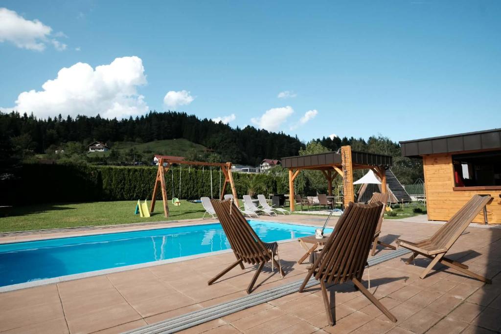 un paio di sedie sedute accanto alla piscina di Kamp Nirvana a Šmartno ob Dreti